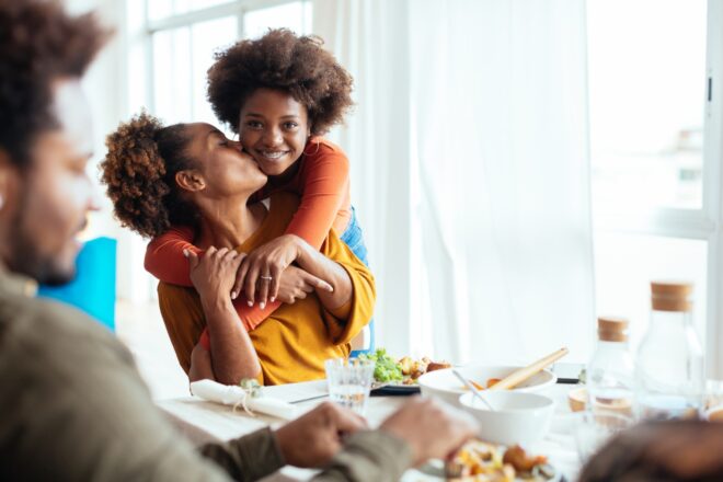 A teenage daughter with her mother at the dinner table